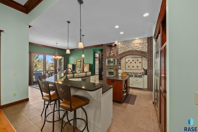 kitchen with stainless steel appliances, a spacious island, a chandelier, ornamental molding, and a kitchen breakfast bar