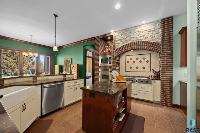 kitchen with stainless steel appliances, decorative backsplash, a sink, tile patterned floors, and decorative light fixtures