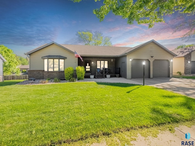 ranch-style house featuring covered porch, an attached garage, brick siding, and driveway