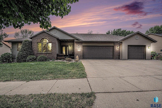 711 Britz Dr, Luverne, MN 56156 - single story home with an attached garage, concrete driveway, a front yard, and brick siding
