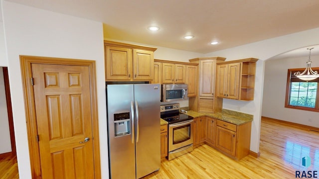851 Regency Ct, Brookings, SD 57006 - kitchen featuring stainless steel appliances, light wood finished floors, open shelves, light stone counters, and arched walkways