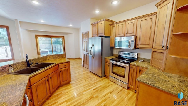 851 Regency Ct, Brookings, SD 57006 - kitchen with stainless steel appliances, a sink, light wood-style flooring, recessed lighting, and light stone counters