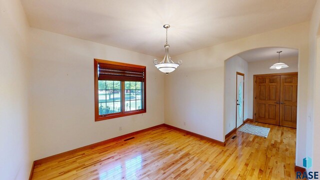 851 Regency Ct, Brookings, SD 57006 - spare room with arched walkways, light wood-type flooring, and baseboards