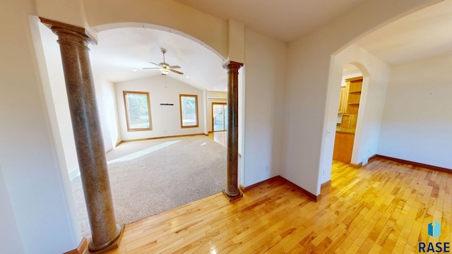 851 Regency Ct, Brookings, SD 57006 - hallway featuring ornate columns, light wood-style flooring, lofted ceiling, and arched walkways