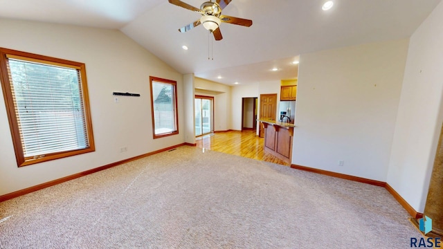 851 Regency Ct, Brookings, SD 57006 - unfurnished living room with light carpet, ceiling fan, recessed lighting, baseboards, and lofted ceiling