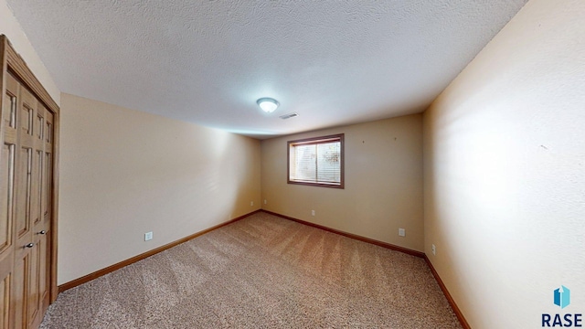 851 Regency Ct, Brookings, SD 57006 - unfurnished bedroom featuring light colored carpet, baseboards, a closet, and a textured ceiling