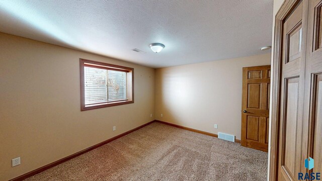 851 Regency Ct, Brookings, SD 57006 - empty room with light carpet, baseboards, and a textured ceiling