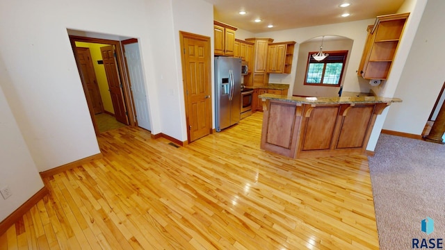 851 Regency Ct, Brookings, SD 57006 - kitchen with appliances with stainless steel finishes, open shelves, a peninsula, light wood finished floors, and light stone countertops