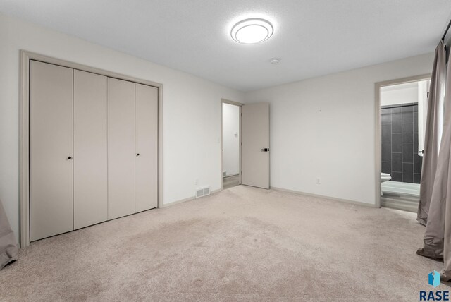 1335 Blue Ox St, Harrisburg, SD 57032 - unfurnished bedroom featuring a closet, light colored carpet, connected bathroom, and baseboards