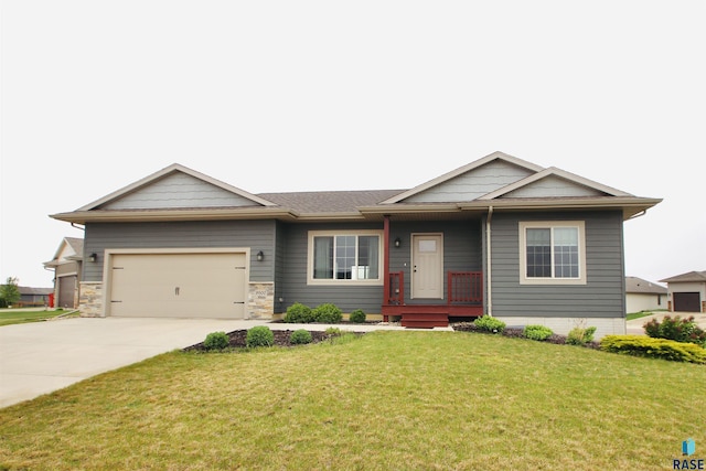 view of front of property with concrete driveway, a front lawn, a garage, and a porch