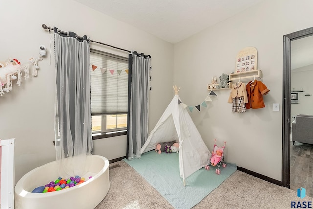 recreation room with carpet and baseboards