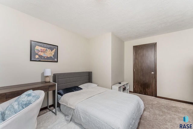 bedroom with light colored carpet, a textured ceiling, and baseboards