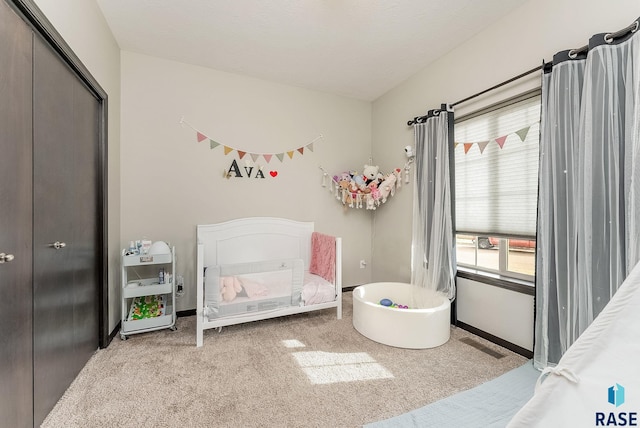 carpeted bedroom with baseboards and a closet