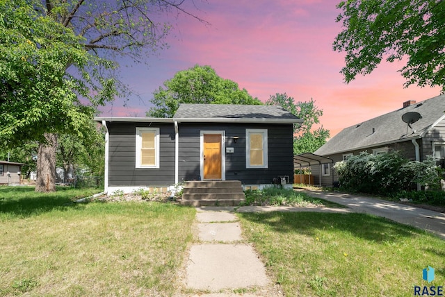 view of front of home with a front yard and a carport
