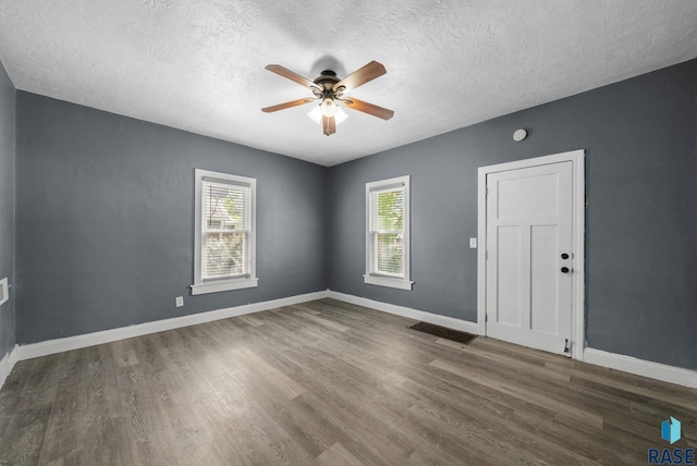 unfurnished room featuring ceiling fan, a textured ceiling, wood finished floors, and baseboards