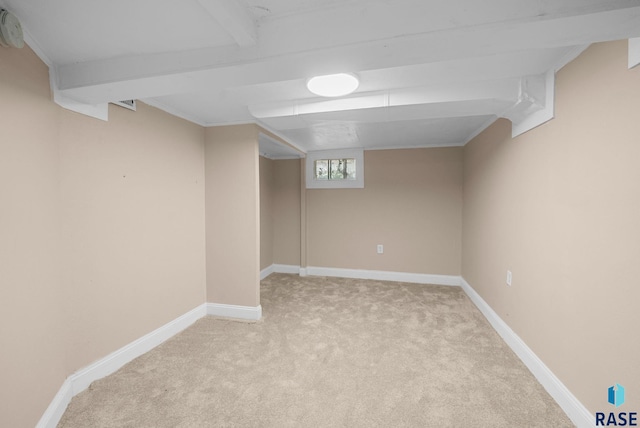 below grade area featuring light carpet and baseboards