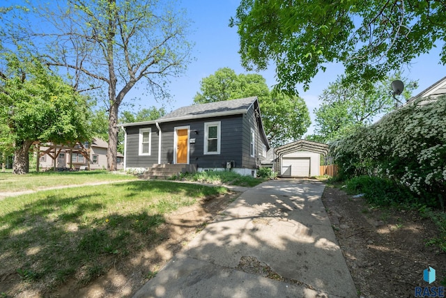 bungalow featuring a detached garage, an outdoor structure, driveway, and a front yard