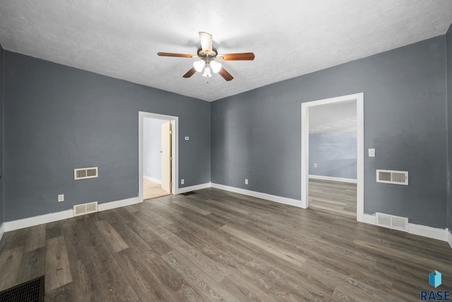 empty room with ceiling fan, a textured ceiling, wood finished floors, and baseboards