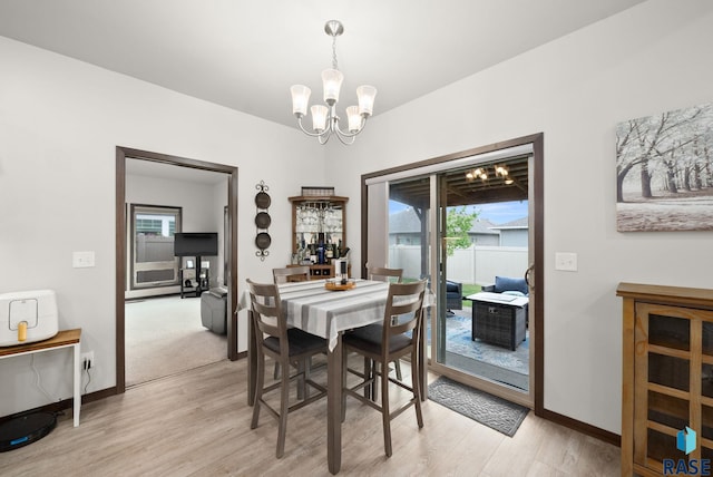 dining space featuring a chandelier, light wood-style floors, and baseboards