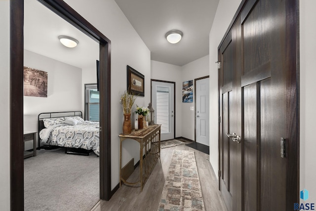 foyer entrance with wood finished floors and baseboards