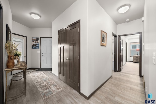foyer entrance featuring light wood-style flooring and baseboards