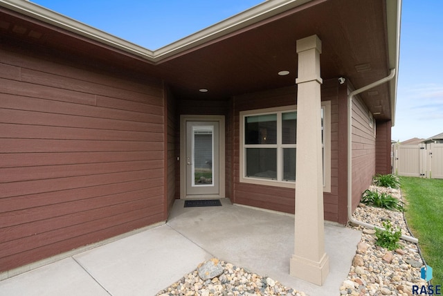 property entrance with a patio, a gate, and fence