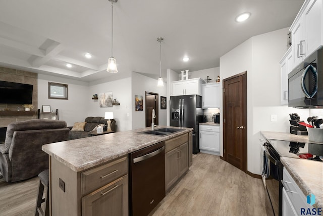 kitchen with black appliances, a sink, open floor plan, light wood finished floors, and recessed lighting