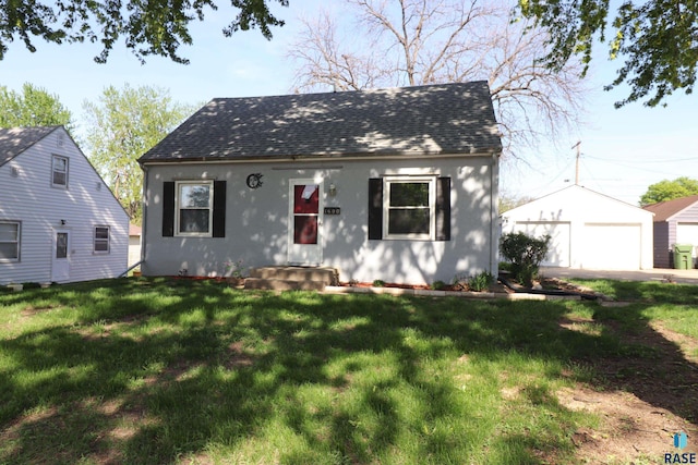 view of front of property featuring a detached garage, an outbuilding, roof with shingles, and stucco siding