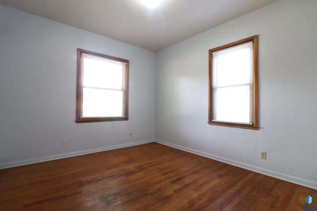 empty room featuring wood finished floors and baseboards