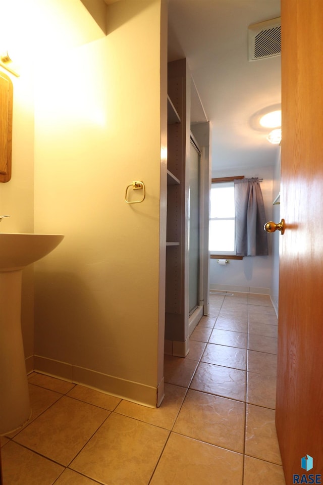 hall featuring baseboards and tile patterned flooring