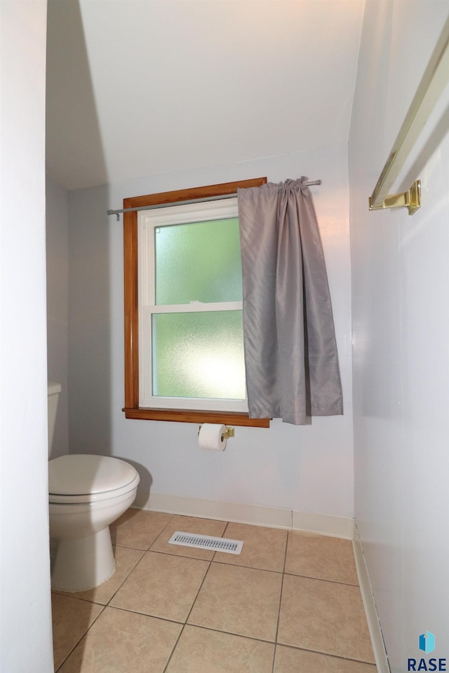 bathroom featuring toilet, tile patterned flooring, and baseboards