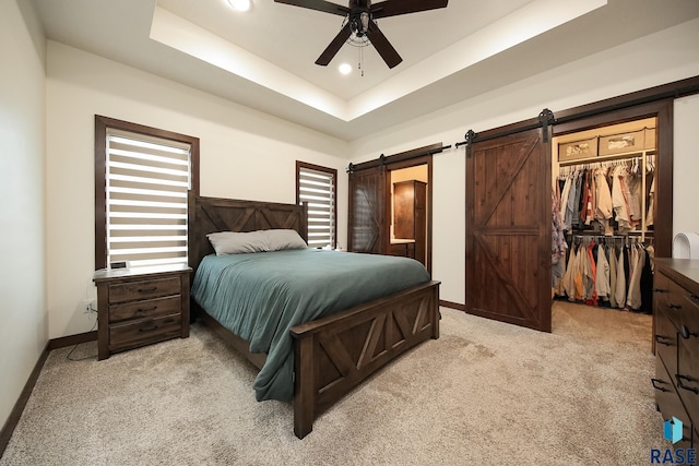 812 Trojan Ave, Hartford, SD 57033 - carpeted bedroom featuring a barn door, a raised ceiling, a spacious closet, baseboards, and a closet