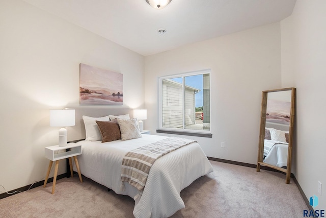 bedroom with light carpet and baseboards