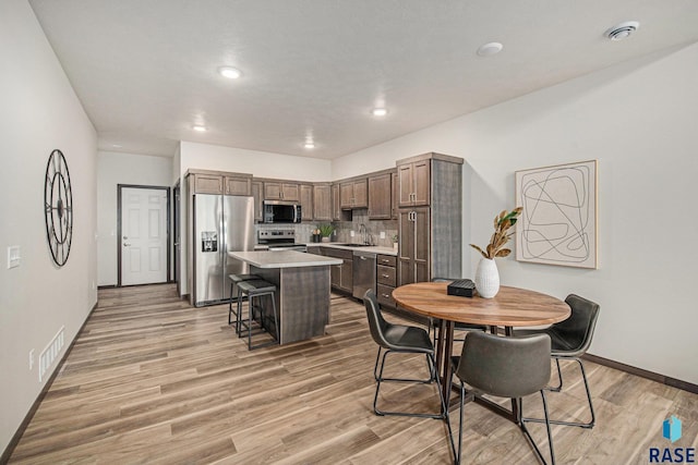 dining area with light wood-style flooring, baseboards, and recessed lighting