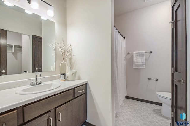 bathroom with toilet, vanity, tile patterned floors, and baseboards