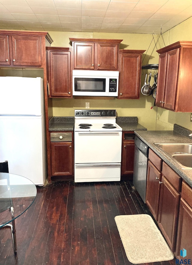 305 S 5th St, Menno, SD 57045 - kitchen featuring white appliances, a sink, dark wood finished floors, and dark countertops