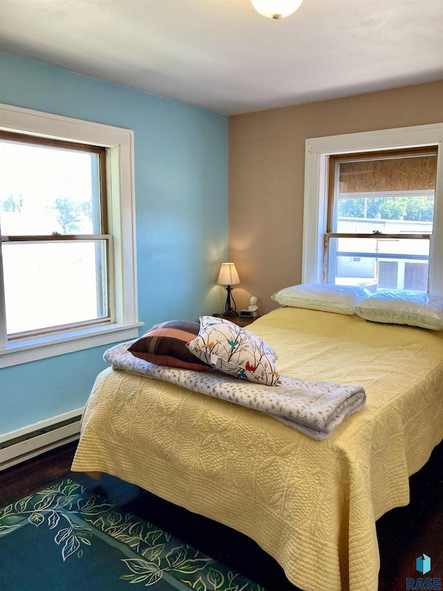 305 S 5th St, Menno, SD 57045 - bedroom with wood finished floors and a baseboard heating unit