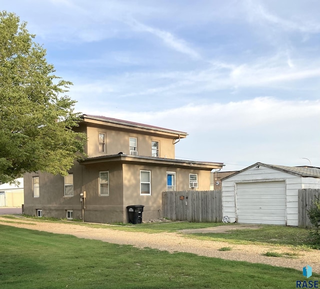 305 S 5th St, Menno, SD 57045 - back of property with an outdoor structure, driveway, stucco siding, and a detached garage