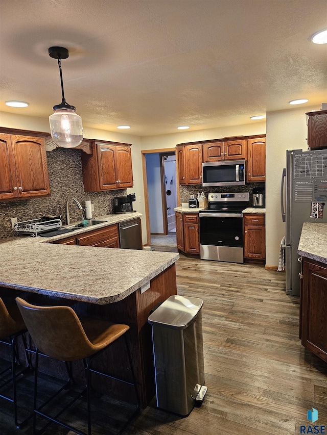 1005 8th Ave, Pipestone, MN 56164 - kitchen with stainless steel appliances, a sink, decorative backsplash, a kitchen bar, and a peninsula