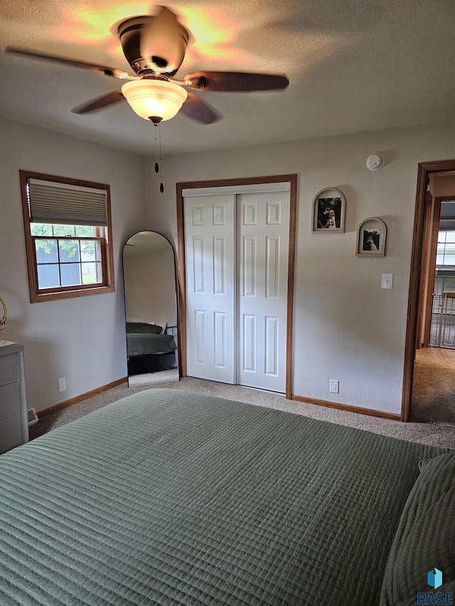 1005 8th Ave, Pipestone, MN 56164 - unfurnished bedroom featuring carpet flooring, a closet, a ceiling fan, baseboards, and a textured ceiling