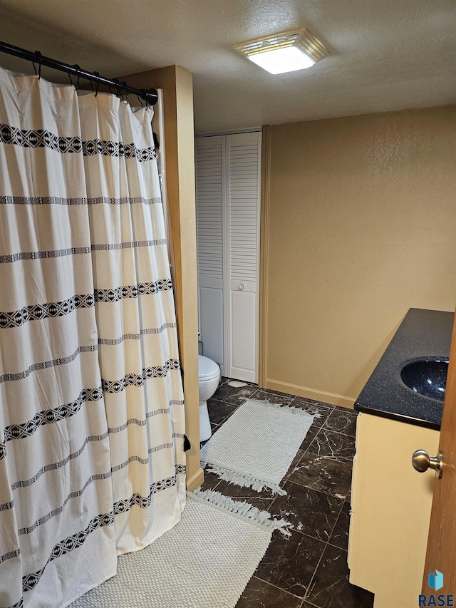 1005 8th Ave, Pipestone, MN 56164 - full bathroom with marble look tiles, vanity, toilet, a textured ceiling, and a closet