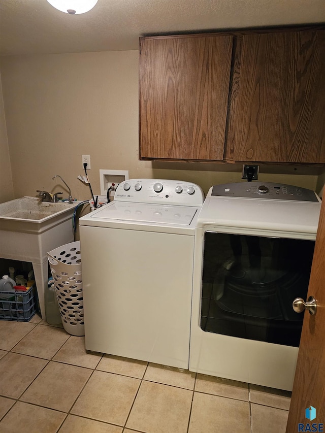 1005 8th Ave, Pipestone, MN 56164 - laundry room with washing machine and dryer, cabinet space, and light tile patterned floors