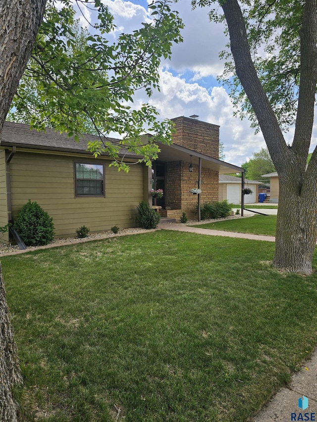 1005 8th Ave, Pipestone, MN 56164 - view of front of property featuring a chimney, an attached garage, a front lawn, and brick siding