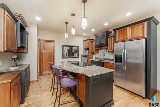 5616 S Shadow Wood Pl, Sioux Falls, SD 57108 - kitchen with black appliances, light wood finished floors, a kitchen island, a sink, and recessed lighting