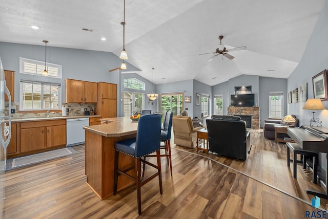 7200 S Hoffman Pl, Sioux Falls, SD 57108 - kitchen with white dishwasher, dark wood-style flooring, lofted ceiling, brown cabinetry, and a center island
