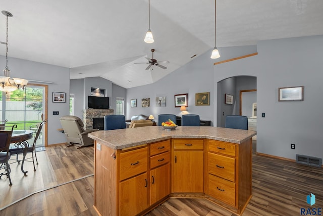 7200 S Hoffman Pl, Sioux Falls, SD 57108 - kitchen with arched walkways, a fireplace, vaulted ceiling, dark wood finished floors, and ceiling fan