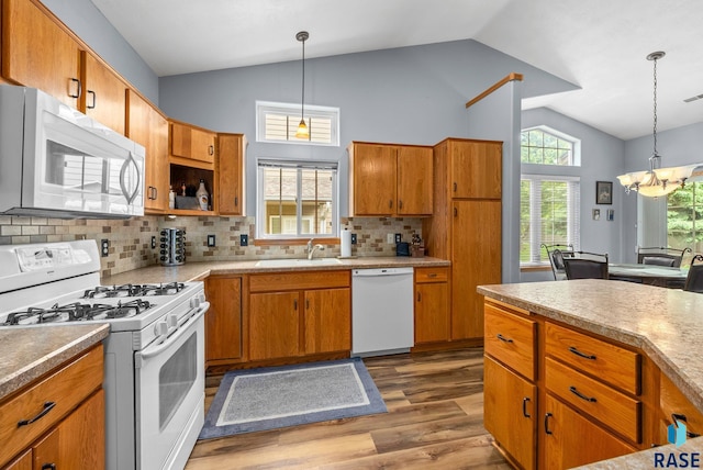 7200 S Hoffman Pl, Sioux Falls, SD 57108 - kitchen with white appliances, lofted ceiling, a sink, a chandelier, and wood finished floors