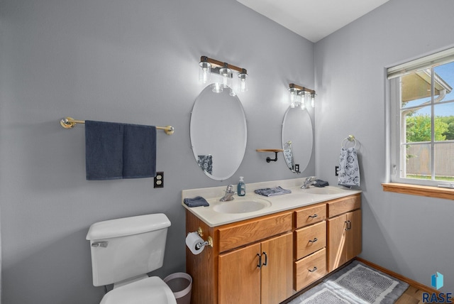 7200 S Hoffman Pl, Sioux Falls, SD 57108 - bathroom featuring double vanity, toilet, and baseboards