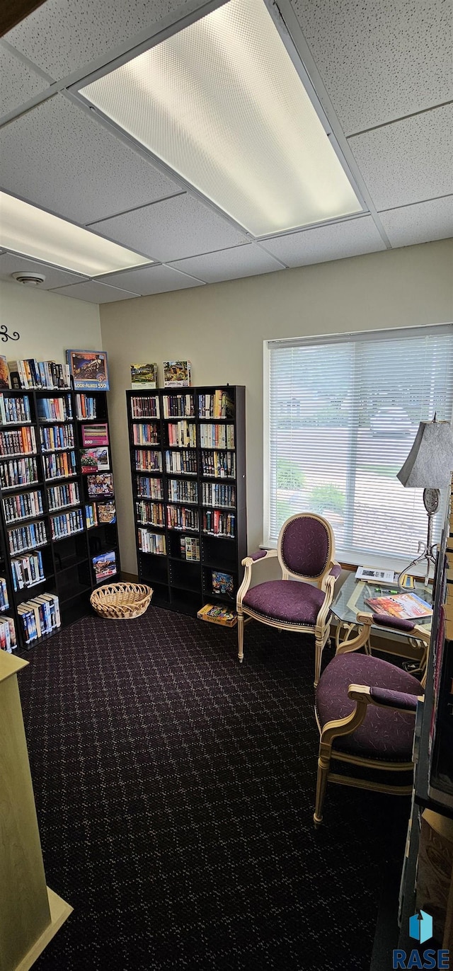 7200 S Hoffman Pl, Sioux Falls, SD 57108 - sitting room featuring carpet, wall of books, and a paneled ceiling