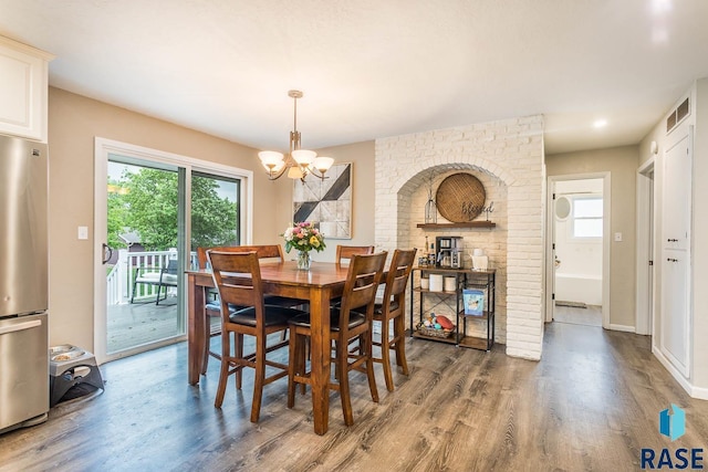 1002 N Carol St, Luverne, MN 56156 - dining room featuring wood finished floors, a chandelier, plenty of natural light, and baseboards